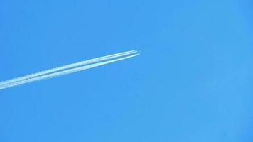 Kondensstreifen am blauen Himmel. Flugzeug fliegt hoch. Zeitlupe video