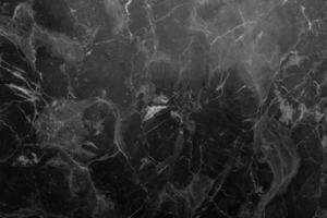 Gray marble background with light inclusions. Dark coating with light veins. photo