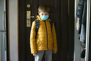 A masked child goes to school after being quarantined and isolated from the coronavirus. photo