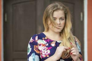 Sad pensive blonde girl with blue eyes on the street. photo