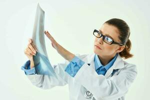 mujer médico en blanco Saco mirando a radiografía diagnósticos de cerca foto