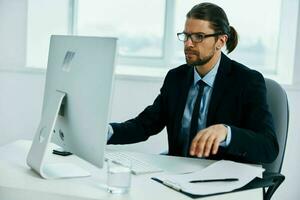 hombre en un traje sentado a un escritorio en frente de un computadora jefe foto