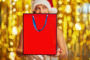 Young woman with shopping bags over gold background photo