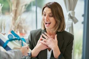 Picture of woman holding a gift in restaurant photo