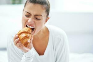 Young woman on bed with food catering box photo