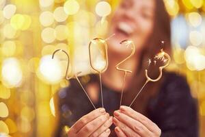 Woman holding 2023 sparklers at new year eve photo
