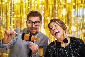 Couple over gold with photo booth accessories on party