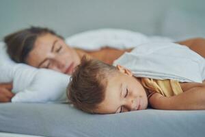 Young mother with 4 years old son in bed photo