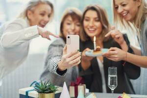 imagen de grupo de muchachas con cumpleaños pastel tomando selfie foto