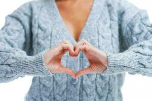 Picture of blonde woman over back isolated background showing heart photo