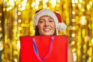 Young woman with shopping bags over gold background photo