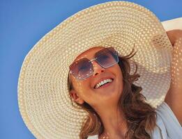 Image of young woman in hat over blue sky photo