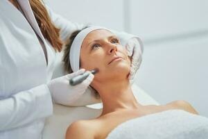 Woman in a beauty salon having needle mesotherapy treatment photo