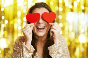 Young woman with heart over gold background photo