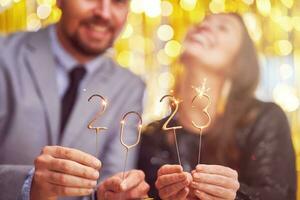 Couple at new year eve party with 2023 sparklers photo