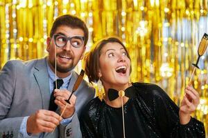 Couple over gold with photo booth accessories on party