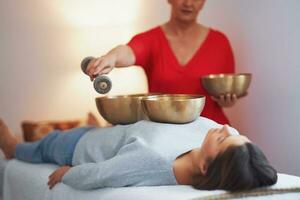 Woman having a Tibetan sound bowl massage photo