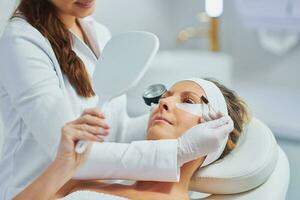 Woman having cosmetology eyebrows treatment in beauty salon photo