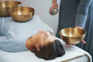 Woman having a Tibetan sound bowl massage photo