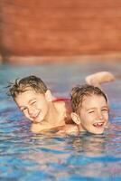 imagen de hermanos jugando en al aire libre agua parque piscina foto