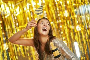 Young woman over gold background with photo booth accessories