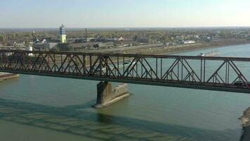 Train Passing Over a River Bridge with a Boat Moving Freight video