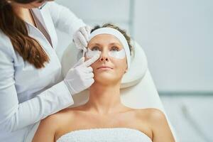 Woman having cosmetology eyebrows treatment in beauty salon photo