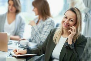 Picture of business woman with cell phone on meeting photo