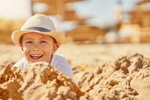 Image of a young boy playing with sand on the beach photo