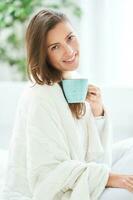 joven bonito mujer en cama con café o té jarra foto