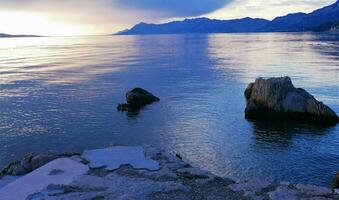 Beautiful purple sunset horizon and big rocks photo