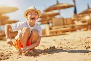 imagen de un joven chico jugando con arena en el playa foto