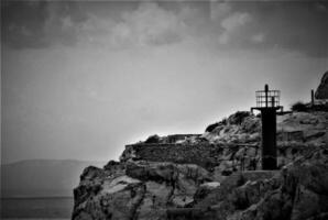 Lighthouse on the rock by the sea photo