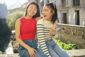 Cheerful Asian women having fun on street photo