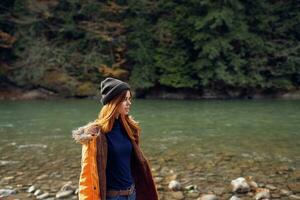 woman tourists yellow jacket nature river travel autumn photo