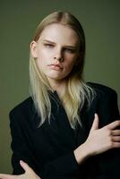 The concept of the women's movement. A strong self-confident serious successful girl crosses her arms on her chest and looks into the camera posing on a green background photo