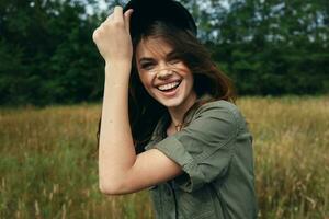 Happy woman in blue cap and green shirt laughs photo