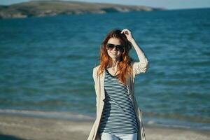 woman in sunglasses in summer outdoors on the beach sea travel photo