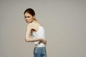 disgruntled woman back pain health problems osteoporosis light background photo