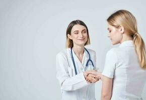 Happy woman doctor in medical gown with stethoscope and patient back view photo