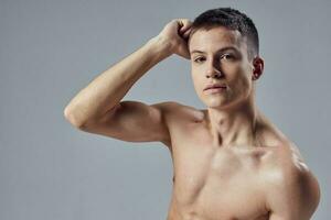 man with bare shoulders athletic physique hand near head close-up photo