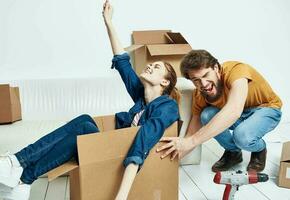 Cheerful young couple in an apartment boxes with things moving photo