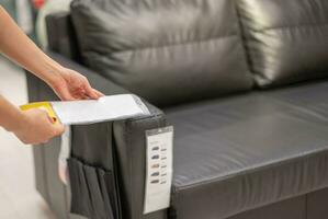 Female hand selecting the satin of cover sofa at the interior and furniture store. photo