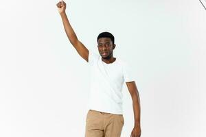 hombre africano apariencia en blanco camiseta sostener mano encima cabeza recortado ver moderno estilo estudio foto