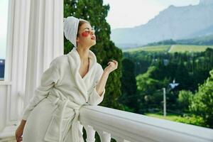 Portrait woman in a robe stands on an open balcony unaltered photo