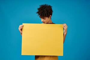 Cheerful guy with yellow phosphorus on a blue background Copy Space photo