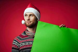 handsome man in a santa hat holding a banner holiday studio posing photo