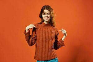 red-haired woman in red sweater fashion studio posing photo