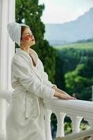 Sensual and beautiful woman stands on the balcony of the hote looking on the view photo