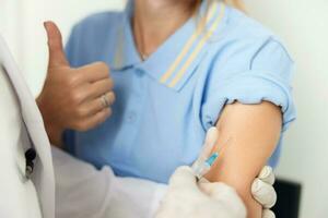 patient showing thumb up injection treatment hospital covid vaccination photo